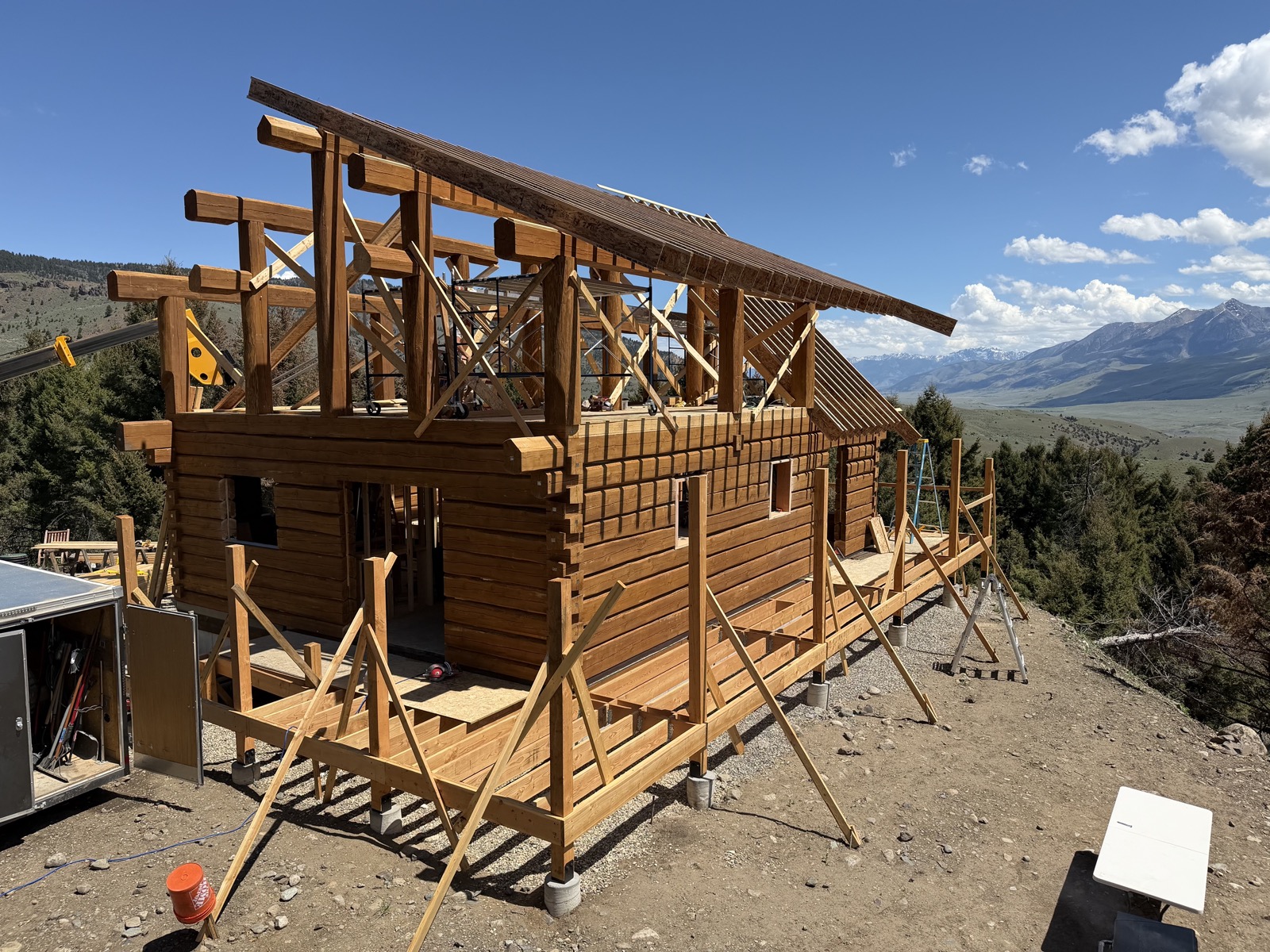 Timber-frame home under construction with mountain views